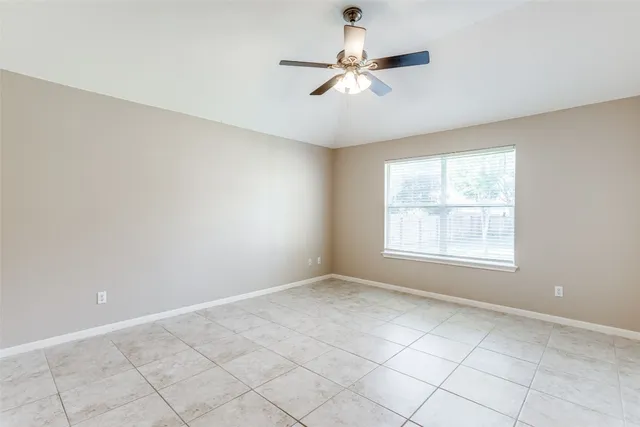 an empty room with a window and a fan