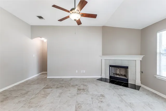 an empty room with fireplace and fan