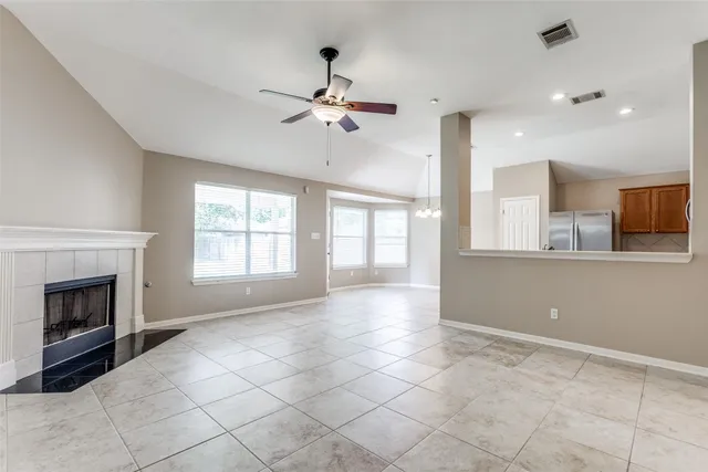 a view of an empty room with a fireplace and a window