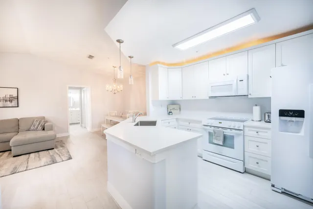 a kitchen with a sink dishwasher a stove a dining table and chairs