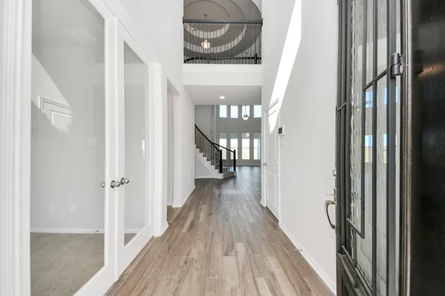 a view of a hallway with wooden floor and staircase