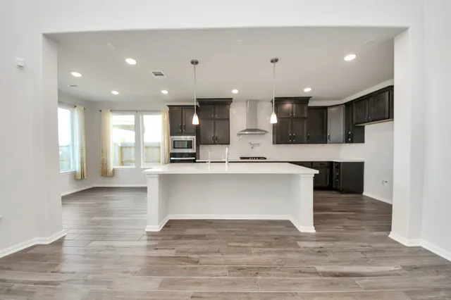 a view of kitchen with kitchen island a sink and a stove