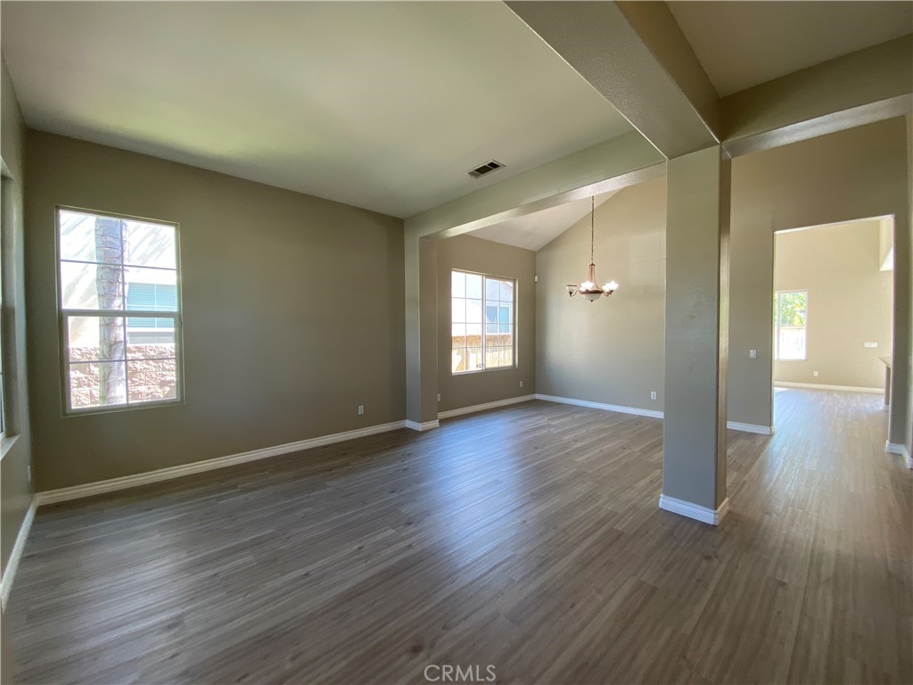 a view of empty room with window and wooden floor