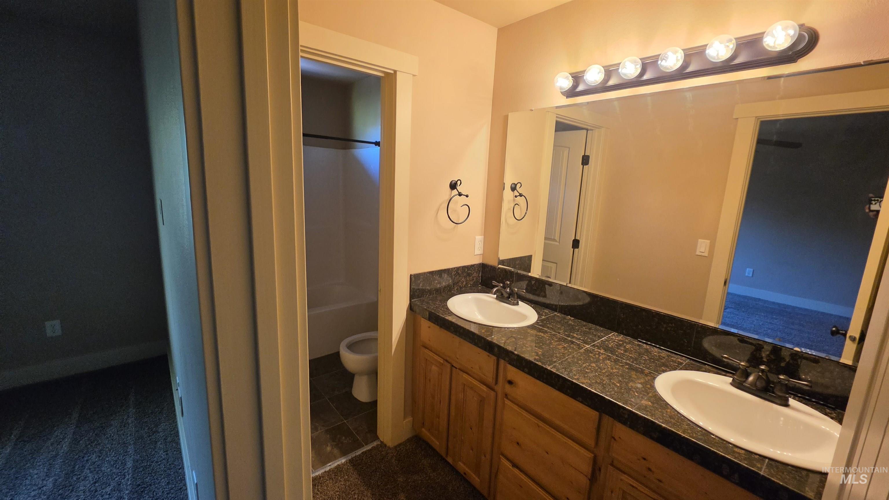 5239 West Morris Hill Road Boise, ID 83706 - Photo 13 of 19 Dual vanity with granite-finish countertop, undermount sinks, and wood-finish cabinetry