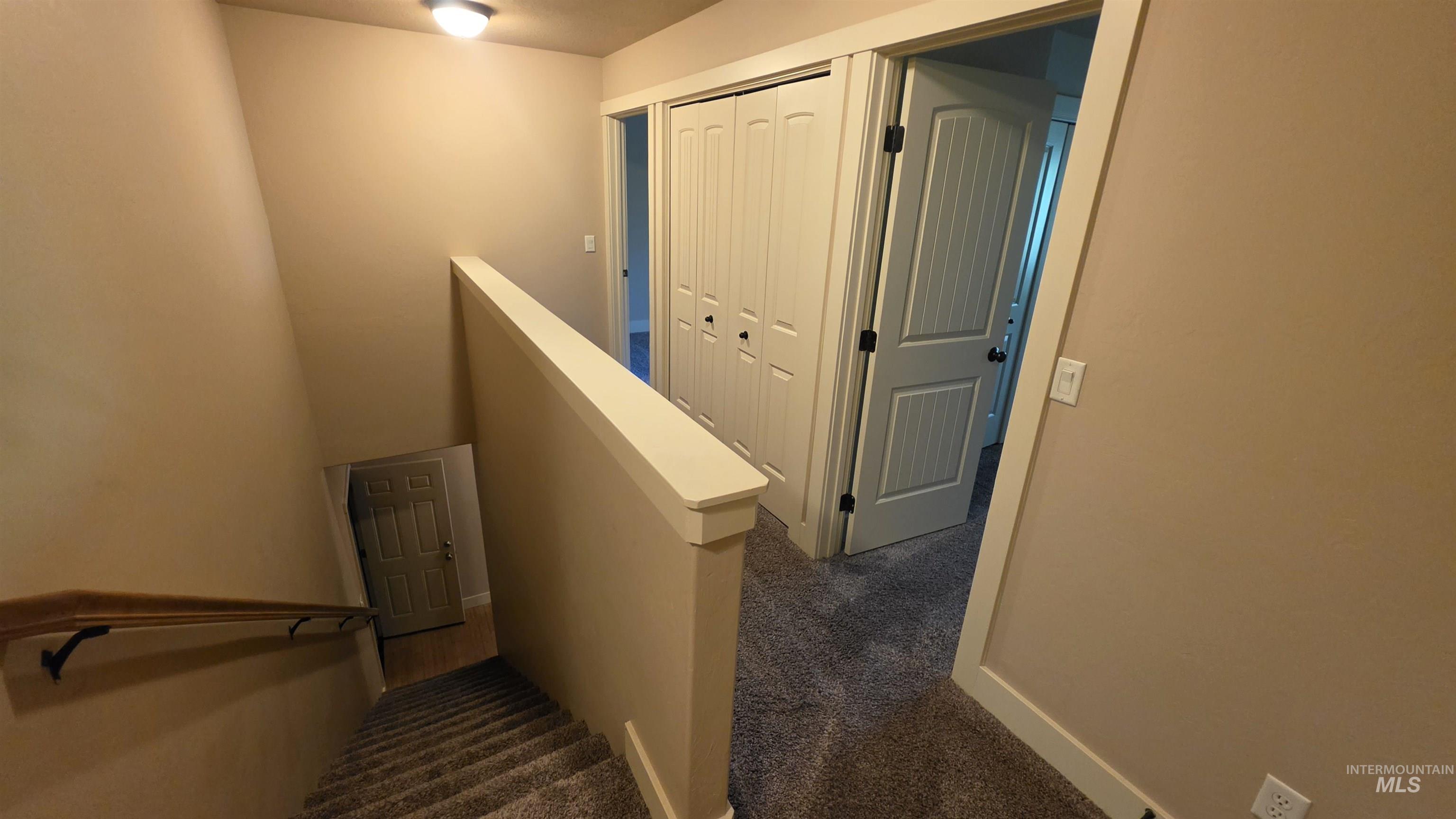 5239 West Morris Hill Road Boise, ID 83706 - Photo 8 of 19 Carpeted stairway with a wood handrail leading to a carpeted upper landing