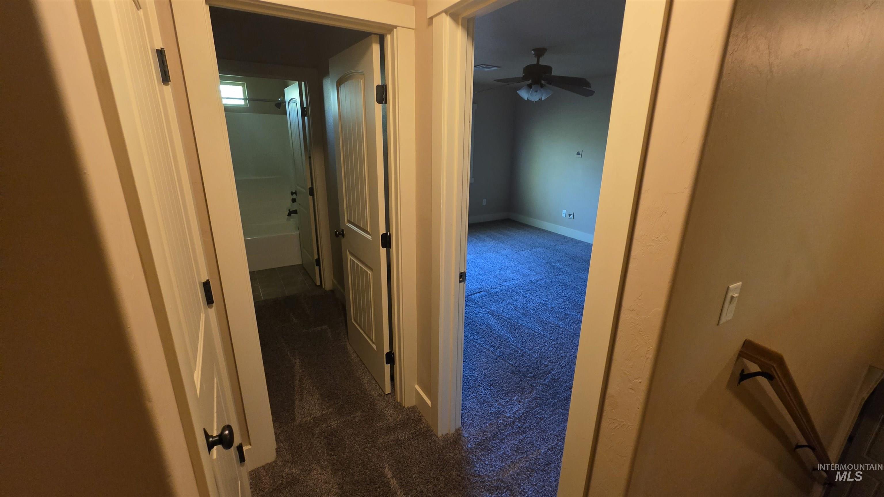 5239 West Morris Hill Road Boise, ID 83706 - Photo 9 of 19 Hallway with neutral wall tones and dark carpet flooring