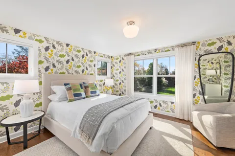 a bedroom with a bed couch and a large window with outer view