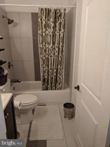 a bathroom with a toilet and a shower curtain