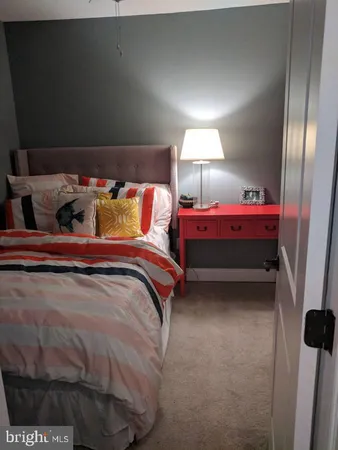 a bed sitting in a bedroom next to a lamp