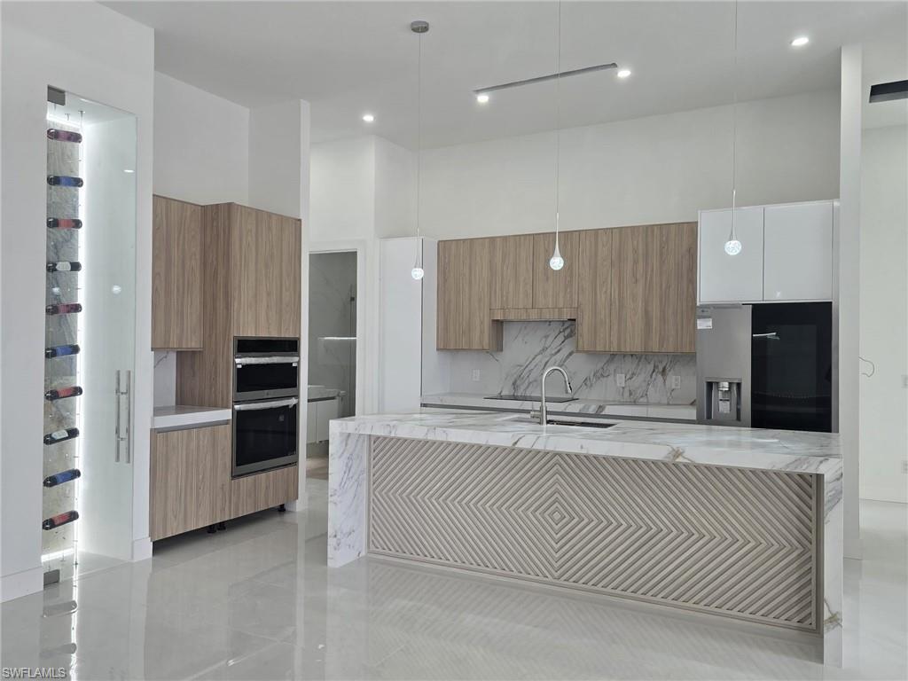 2006 Nelson Road North Cape Coral, FL 33993 - Photo 16 of 50 a large kitchen with stainless steel appliances kitchen island a large counter top and stove