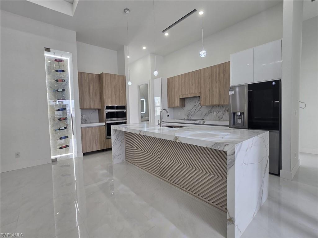 2006 Nelson Road North Cape Coral, FL 33993 - Photo 17 of 50 a kitchen with stainless steel appliances a refrigerator sink and microwave