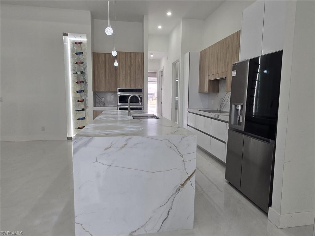 2006 Nelson Road North Cape Coral, FL 33993 - Photo 18 of 50 a kitchen with stainless steel appliances a refrigerator sink and stove