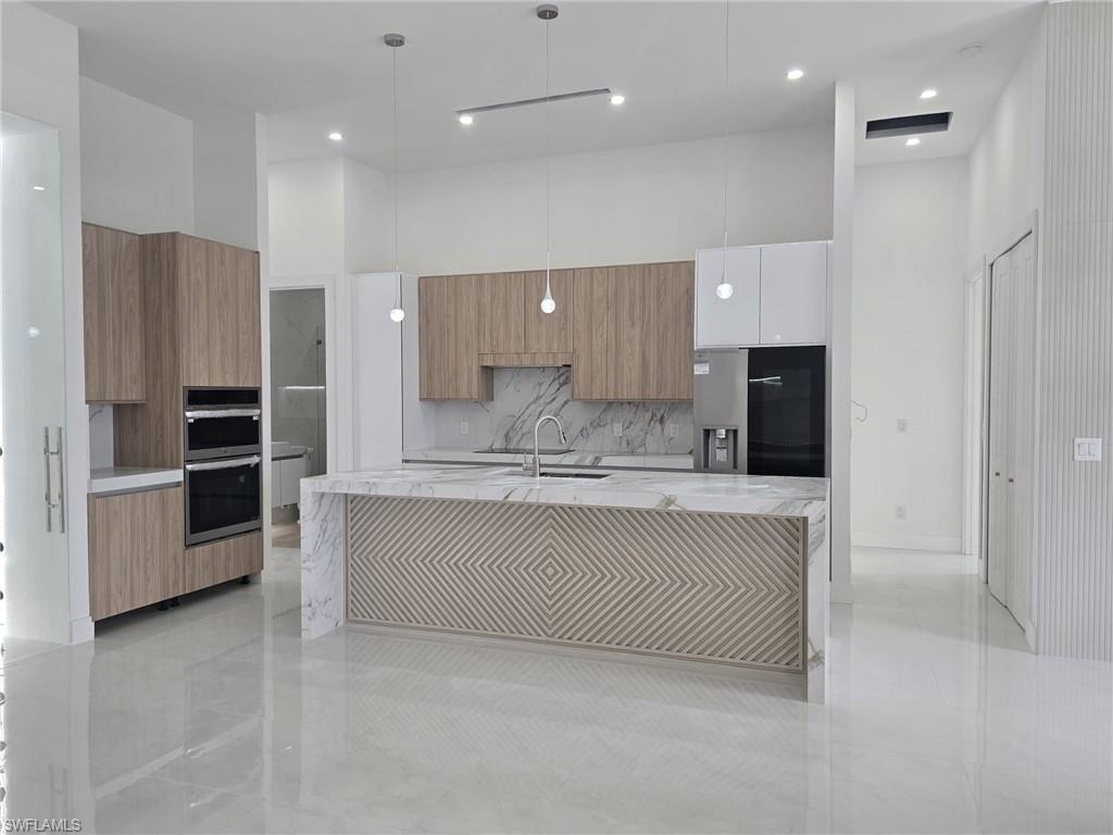 2006 Nelson Road North Cape Coral, FL 33993 - Photo 21 of 50 a large white kitchen with a refrigerator and a stove top oven