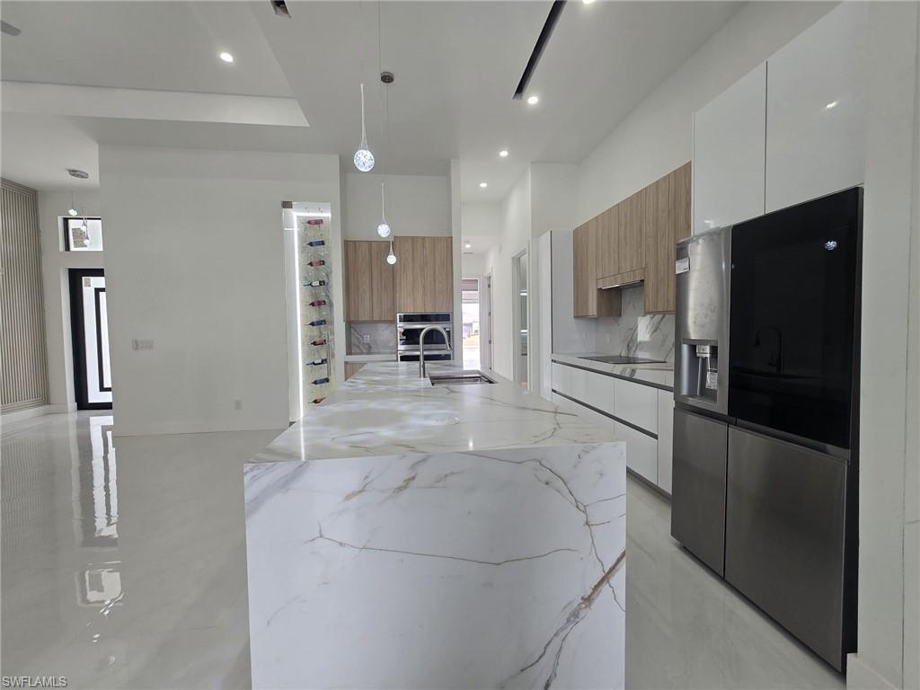 2006 Nelson Road North Cape Coral, FL 33993 - Photo 25 of 50 a kitchen with stainless steel appliances a refrigerator and microwave