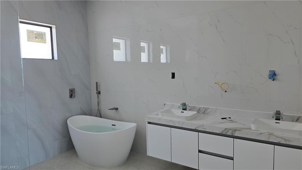 2006 Nelson Road North Cape Coral, FL 33993 - Photo 26 of 50 a bathroom with a tub sink and mirror