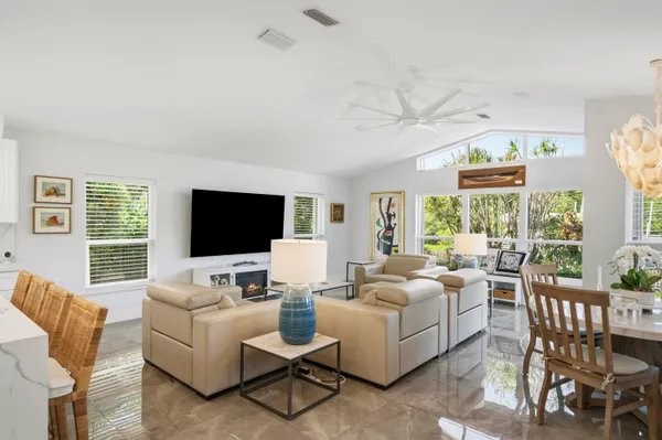 a living room with furniture a flat screen tv and a large window