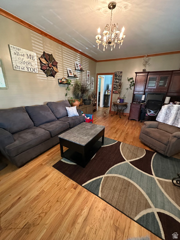 8320 West 3100th Street South Magna, UT 84044 - Photo 7 of 41 Living area with ornamental molding, light wood-style floors, and a chandelier