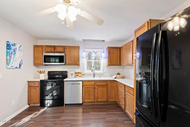 a kitchen with stainless steel appliances a sink cabinets and wooden floor