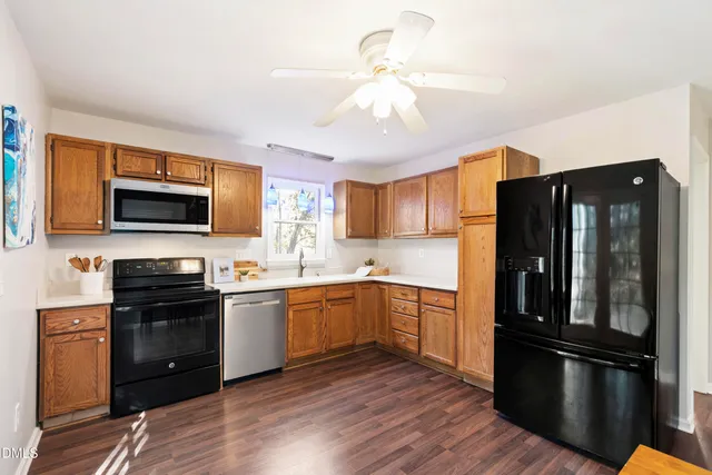 a kitchen with stainless steel appliances granite countertop a refrigerator stove top oven and sink