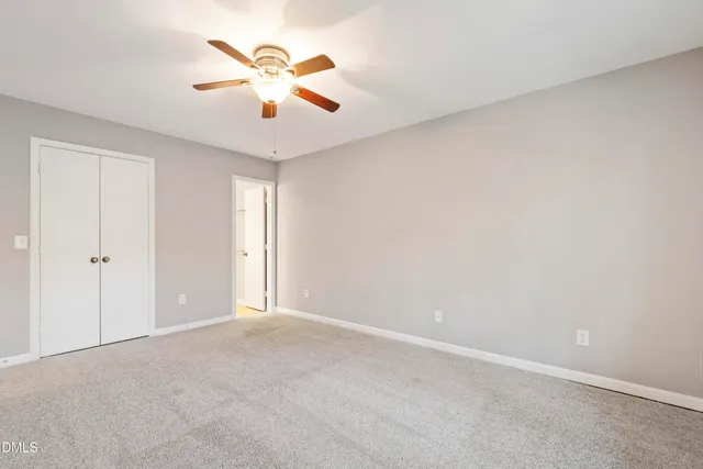 a view of an empty room and chandelier fan