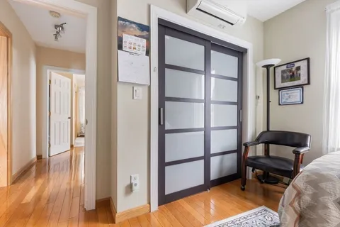 a view of a bedroom with furniture and wooden floor
