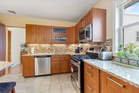 a kitchen with stainless steel appliances granite countertop a sink stove and cabinets