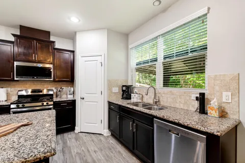 a kitchen with stainless steel appliances granite countertop a sink stove and refrigerator