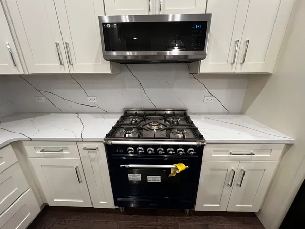 a stove top oven sitting inside of a kitchen
