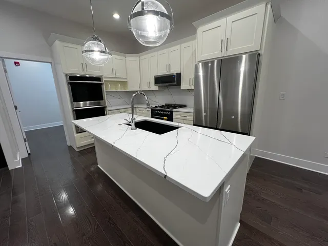 a kitchen with stainless steel appliances a refrigerator sink and microwave