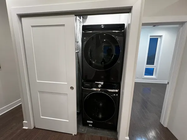 a view of walk in closet with clothes and washer