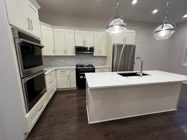 a kitchen with stainless steel appliances a stove refrigerator and a sink