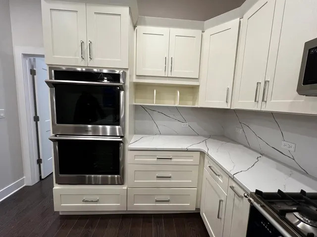 a kitchen with stainless steel appliances white cabinets and a stove