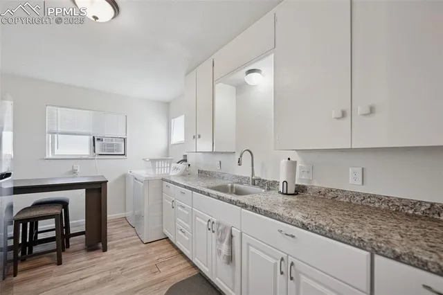 a kitchen with granite countertop white cabinets and sink
