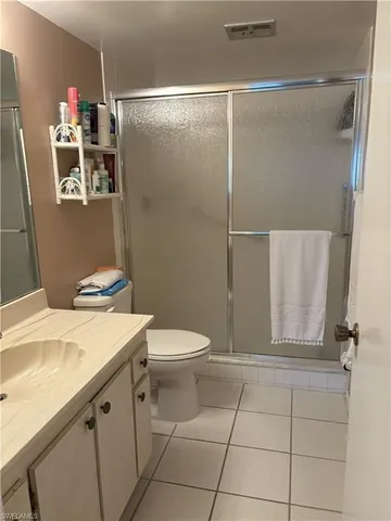 a bathroom with a granite countertop sink a toilet and a shower