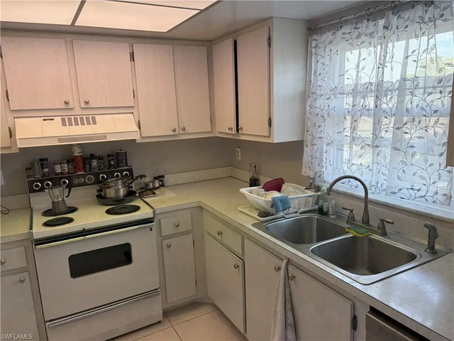 a kitchen with cabinets appliances a sink and a counter top space