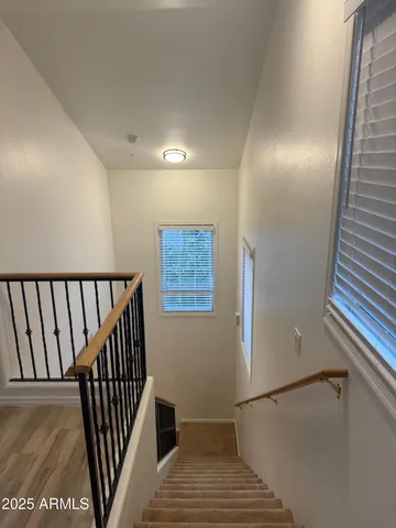 a view of a hallway with wooden floor and staircase