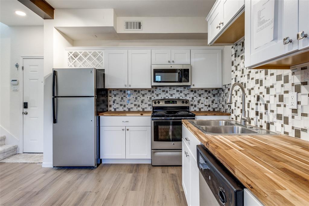 8404 Forest Lane, Unit 702 Dallas, TX 75243 - Photo 7 of 12 a kitchen with stainless steel appliances a refrigerator sink and microwave