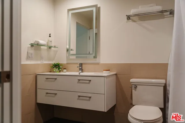 a bathroom with a granite countertop toilet sink and mirror