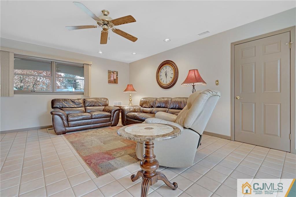 16 Crabtree Road Old Bridge, NJ 07747 - Photo 8 of 25 a living room with furniture a clock and a window