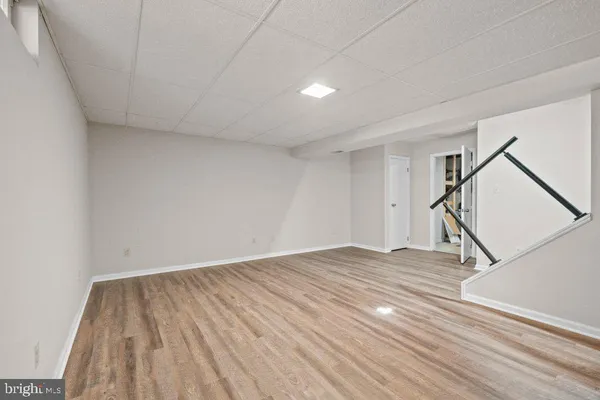 a view of empty room with stairs and wooden floor