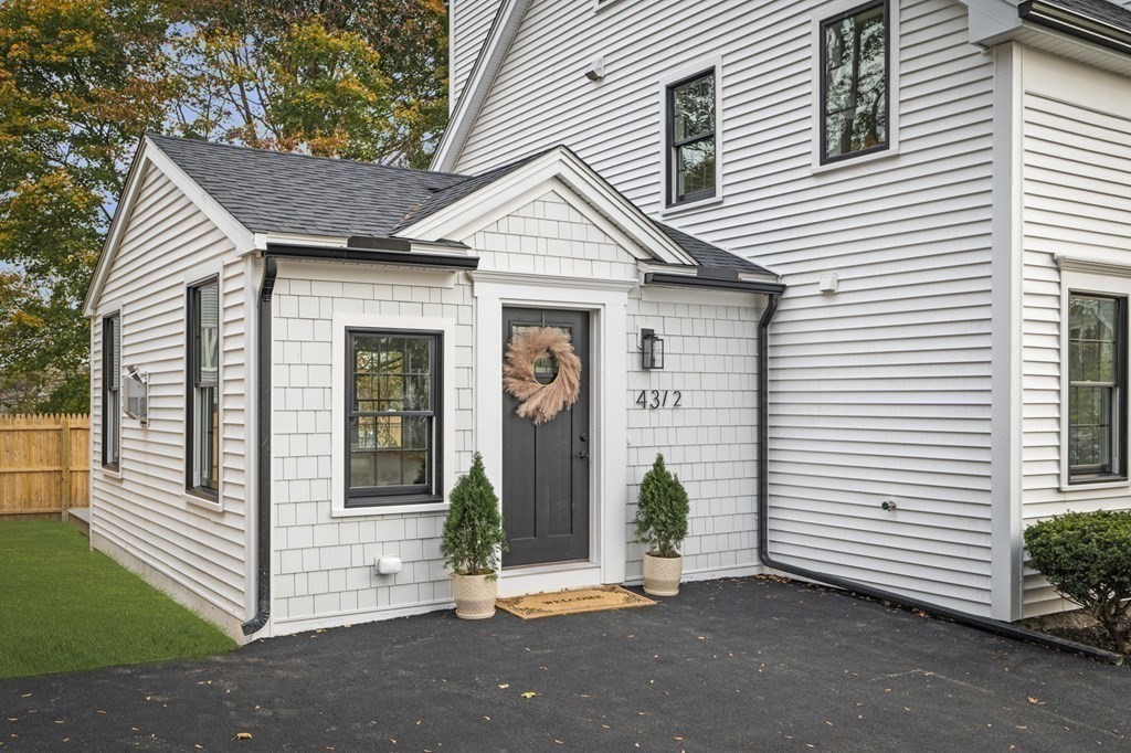 43 Needham Road, Unit 2 Danvers, MA 01923 - Photo 2 of 42 a view of a white house with potted plants and a large tree