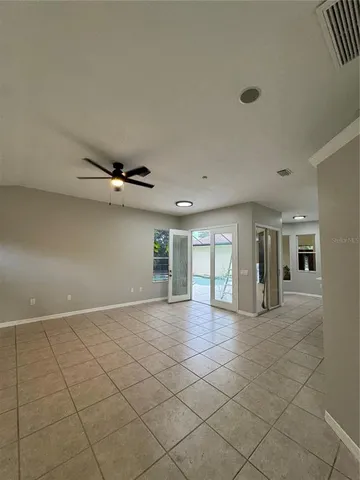 an empty room with windows and chandelier