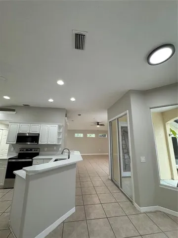 a view of a kitchen with white cabinets and a window