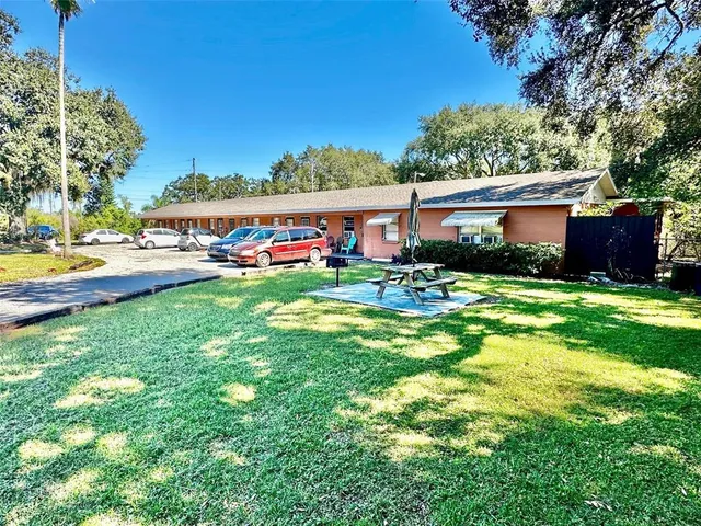 a view of a house with backyard and sitting area