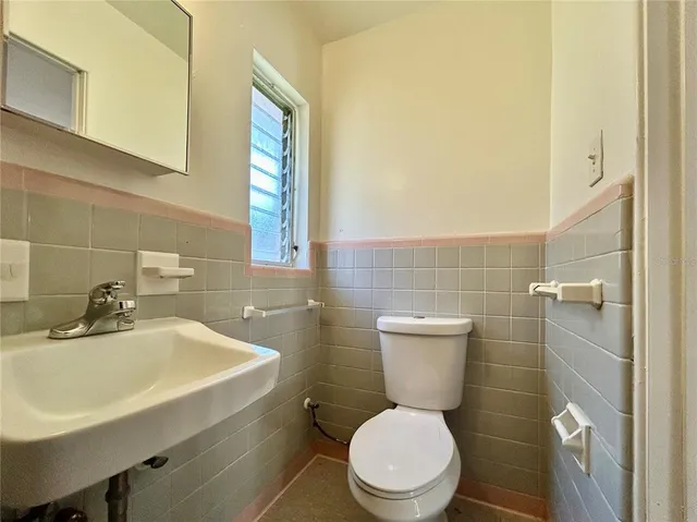 a bathroom with a toilet a sink and a mirror