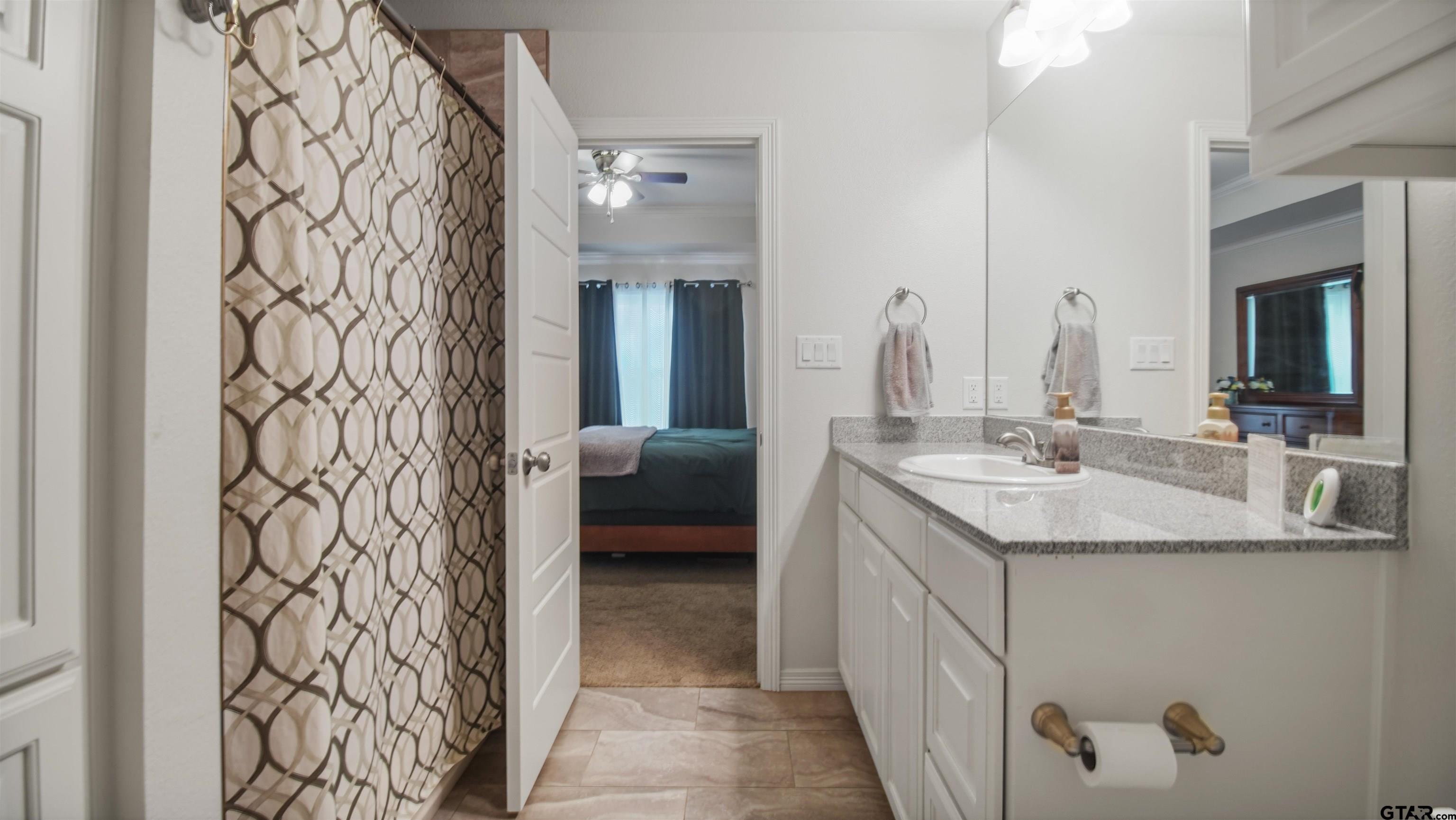 2220 Walton Road Tyler, TX 75701 - Photo 19 of 29 a en suite bathroom with a granite countertop sink and a mirror