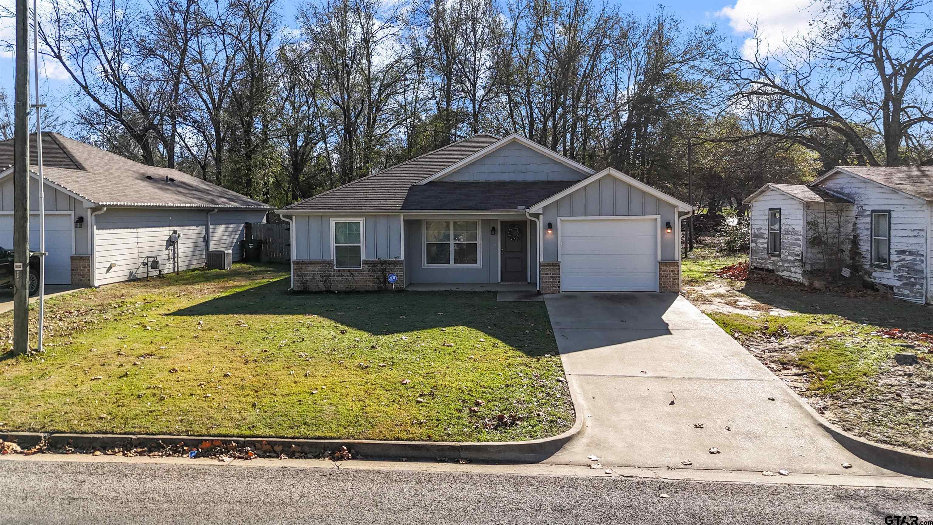 2220 Walton Road Tyler, TX 75701 - Photo 2 of 29 a view of a white house with a yard plants and large tree