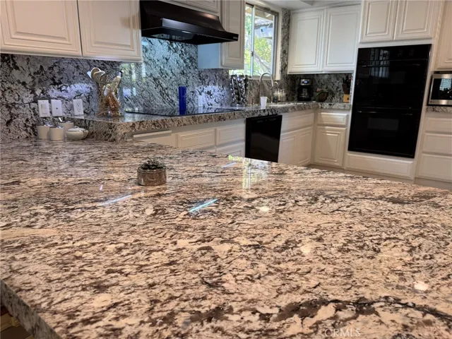 a kitchen with granite countertop a refrigerator stove and sink