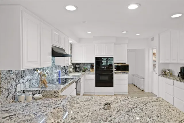a kitchen with stainless steel appliances kitchen island granite countertop a refrigerator sink and cabinets