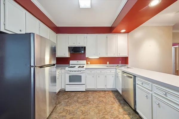 a kitchen with stainless steel appliances granite countertop a refrigerator sink and stove